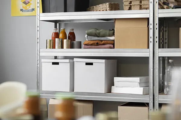 Estante metálica de estoque com caixas e produtos organizados.