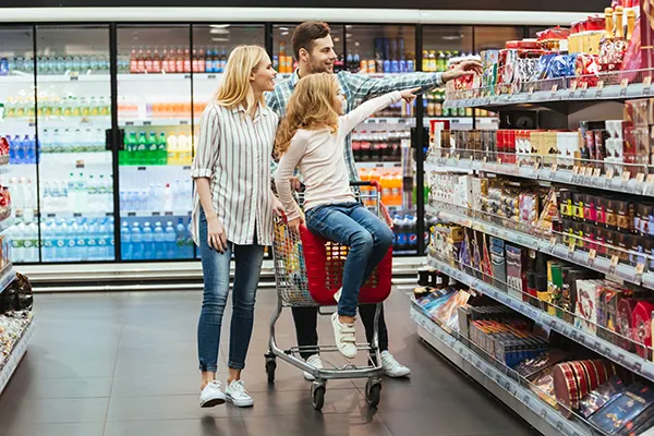 Família escolhendo produtos em um corredor de gôndolas.